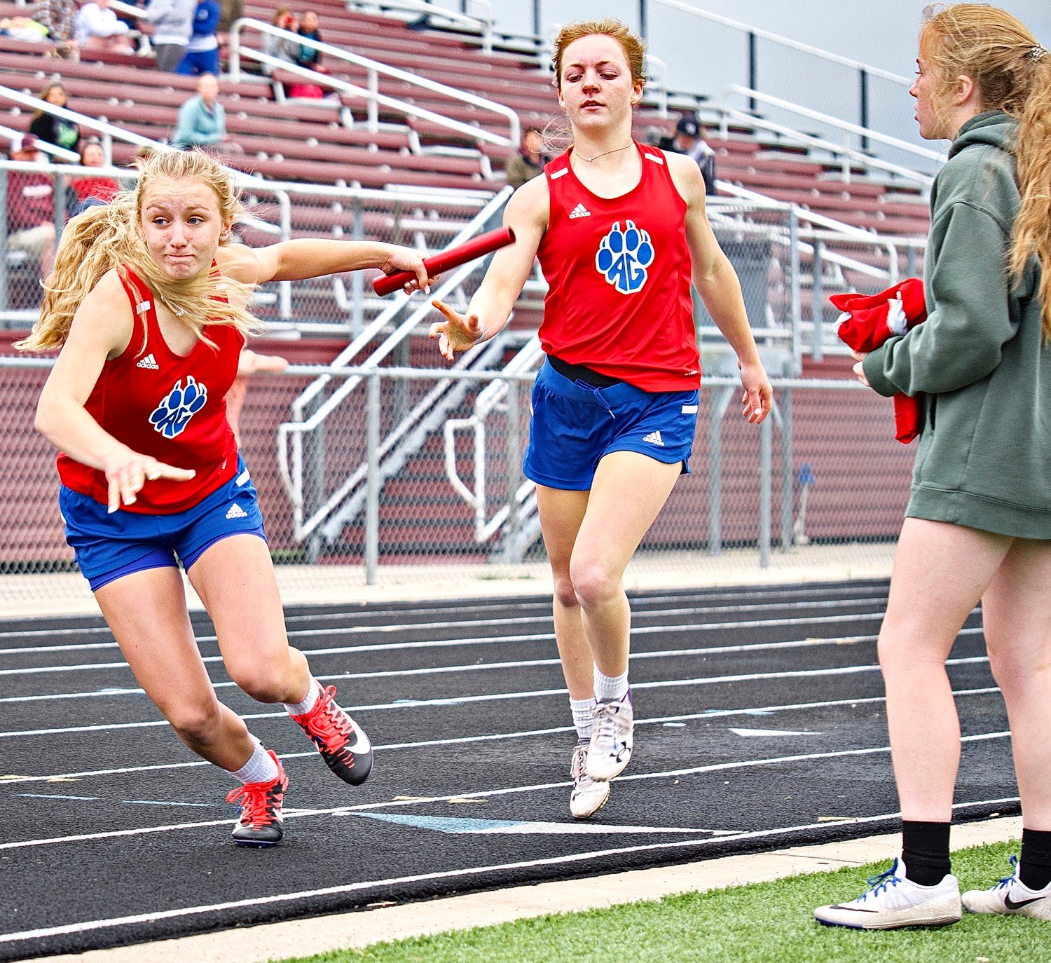 Bella Crawford takes the baton from Cacie Lennon for the third leg of the 4x400 meter relay as Gracie Teel prepares to anchor the race. [more shutter speed]
